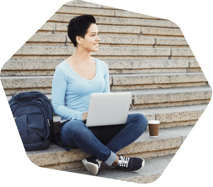 Lady sitting on the steps outside working on her laptop